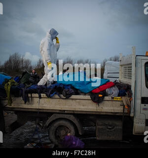 Calais, France. 28 Nov, 2015. Les travailleurs français vêtus de combinaisons blanches de protection de poursuivre l'opération de nettoyage au site migrants à Calais connu sous le nom de la jungle, les travailleurs enlevés supprimés tentes et d'ordures depuis le site et construit de nouveaux points de collecte des ordures. Credit : Duncan Penfold/Alamy Live News Banque D'Images