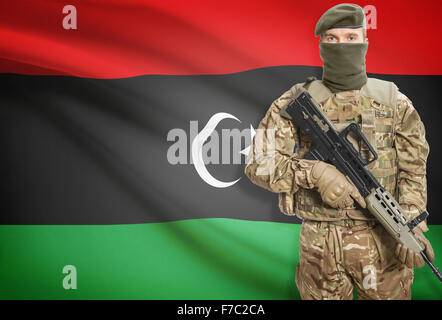 Soldier holding machine gun avec drapeau national sur l'arrière-plan - Libye Banque D'Images