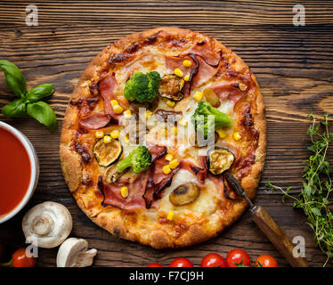 Pizza italien délicieux servi sur table en bois Banque D'Images