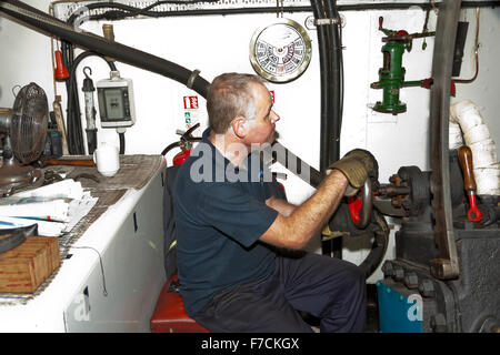 Nigel Thomas, ingénieur de conserves à aubes 'Kingswear Castle' aux commandes dans la salle des machines, Devon, England, UK Banque D'Images