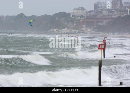 Les surfers et les Kiteboarders équitation vagues de mousse blanche dans une tempête hivernale à Boscombe et Bournemouth, Dorset, UK Banque D'Images