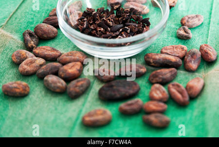 Les fèves de cacao et le bol de plumes Banque D'Images