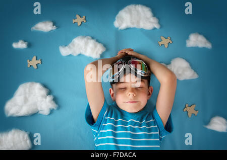 Boy lying on blanket with white clouds Banque D'Images