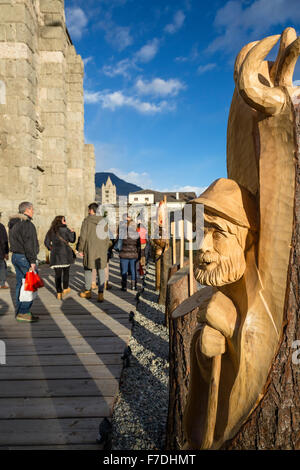 Aosta, Italie - 29 novembre, 2015. Une sculpture en bois décore l'allée vers le marché de Noël. Les consommateurs ont profité du soleil et de températures douces en saison pour visiter le 'Marché' Noël vert - Vert - Marché de Noël qui vient d'ouvrir dans le centre historique de Amphithéâtre romain (théâtre romain). Le marché fonctionne tous les jours à partir de maintenant jusqu'au 6 janvier 2016. Les caractéristiques du marché des produits artisanaux faits à la main à partir de la Val d'Aoste, d'autres parties de l'Italie et autour de l'Europe, ainsi que des spécialités alimentaires produits localement, et des vins de la Région Val d'Aoste. Genyphyr Novak/Alamy Banque D'Images