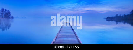 Une petite jetée sur un lac encore sur une paisible matin à l'aube, près d'Amsterdam aux Pays-Bas. Banque D'Images