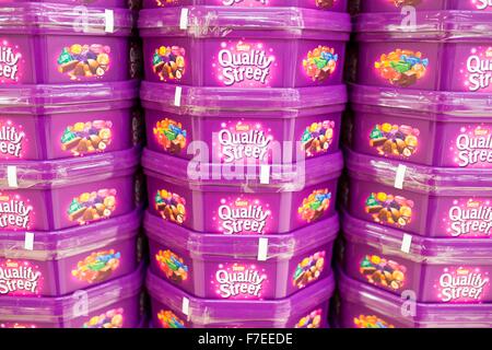 Baignoires de Quality Street chocolats empilés dans un supermarché Banque D'Images