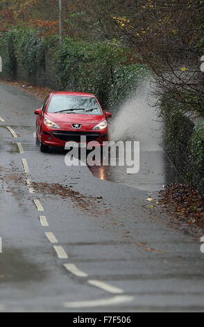 Swansea, Royaume-Uni. Lundi 30 novembre 2015 une voiture Peugeot rouge dans une flaque d'eau à Brynmill Lane, Swansea, Pays de Galles, comme des vents violents et de fortes pluies a été touchant la plupart des régions sur le Royaume-Uni. Credit : D Legakis/Alamy Live News Banque D'Images