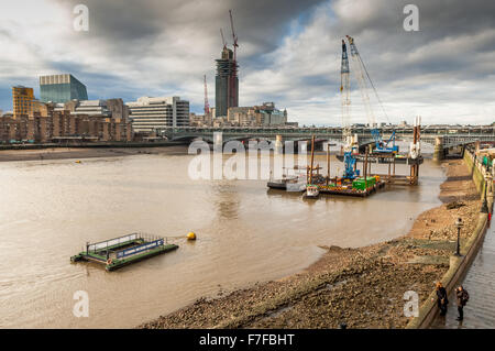 La vue depuis le pont du millénaire à Londres sur la tamise en direction de la ligne de rivage à marée basse. Banque D'Images