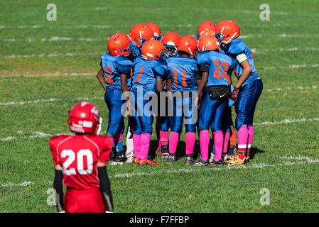 Les jeunes garçons dans le caucus lors d'un match de football Pop Warner, USA Banque D'Images