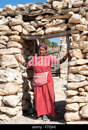 Femme marocaine posant à l'entrée de sa maison à Sidi Kaouki, Maroc. Banque D'Images