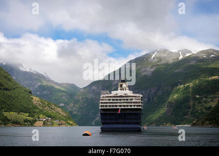 Bateau de croisière grand attaché à une bouée dans l'eau de l'étroite Geirangerfjord entouré de montagnes dans la région de Møre og Romsdal (Norvège). Banque D'Images