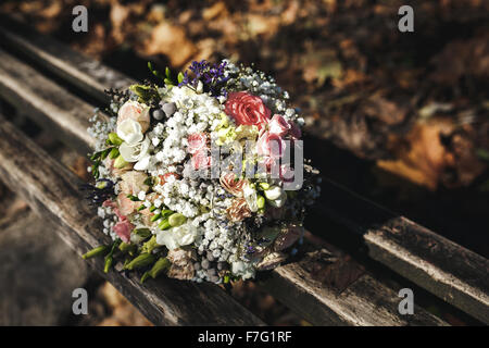 Bouquet de mariée belle couchée sur un banc Banque D'Images