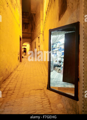 Un miroir reflète un magasin de marchands. Dans une ruelle dans la médina de Fes al Bali. Fes, Maroc, Afrique du Nord. Banque D'Images