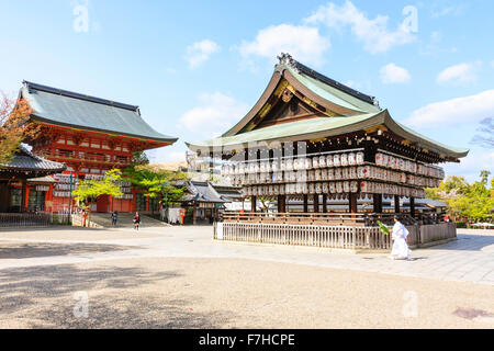 Kyoto, Yasaka. Buden hall avec beaucoup de trois rangées de lanternes en papier, chochin, pendaison. Romon passerelle vermillon en arrière-plan. Prêtre en passant devant. Banque D'Images