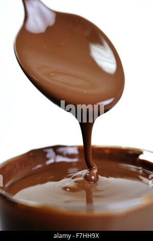 L'analyse macro avec le chocolat chaud tombe d'spooin isolé sur blanc en studio Banque D'Images