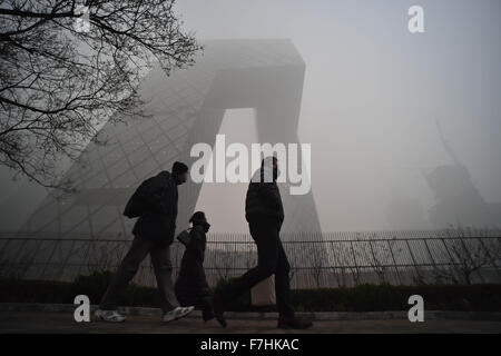 Beijing, Chine. 1er décembre 2015. Des gens portant des masques à la China Central Television (CCTV) siège à Beijing, capitale de Chine, le 1er décembre 2015. Un épais brouillard a frappé Beijing mardi. Credit : Luo Xiaoguang/Xinhua/Alamy Live News Banque D'Images