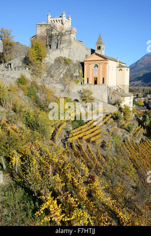 Château et Église de Saint-Pierre au-dessus d'un vignoble aux couleurs automnales à leur sommet.Vallée d'Aoste, Italie. Banque D'Images