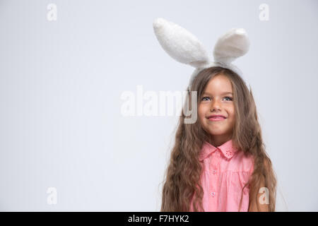 Portrait of a smiling little girl avec oreilles de lapin isolé sur fond blanc Banque D'Images