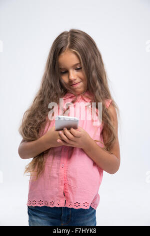 Portrait of a little girl using smartphone isolé sur fond blanc Banque D'Images