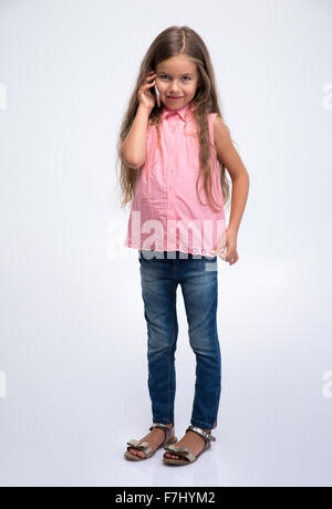 Portrait d'une petite fille au téléphone isolé sur fond blanc Banque D'Images