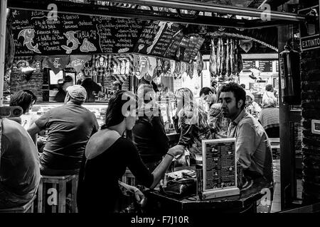 Bar à tapas dans la vieille ville de Benidorm, occupé, en Espagne. Image en noir et blanc, contraste élevé monochrome granuleuses. Banque D'Images