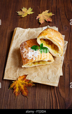 Strudel aux pommes avec une poire sur une table en bois Banque D'Images