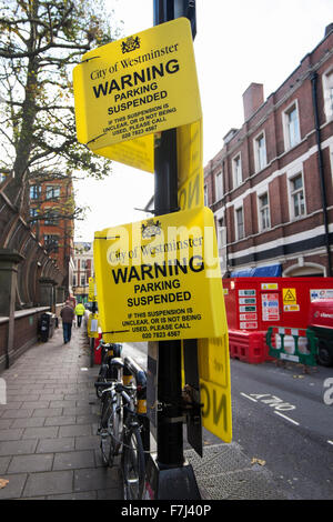 Des panneaux jaunes par la ville de Westminster d'avertissement indiquant que le stationnement est suspendu dans Wardour Street, Soho, London, England, UK Banque D'Images