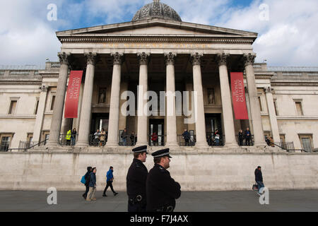 Deux policiers en patrouille devant la face de la National Gallery de Trafalgar square, London, England, UK Banque D'Images