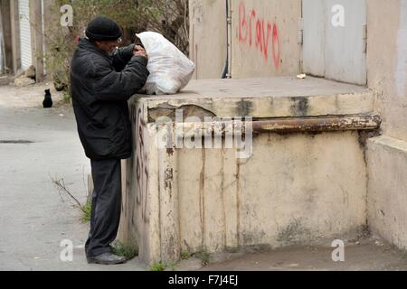 BAKU, Azerbaïdjan - 14 novembre 2013 sans-abri à la recherche de nourriture dans les ordures à Bakou, capitale de l'Azerbaïdjan Banque D'Images