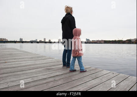 Mère et fille se tenant ensemble sur un quai, à la recherche de l'eau à Banque D'Images