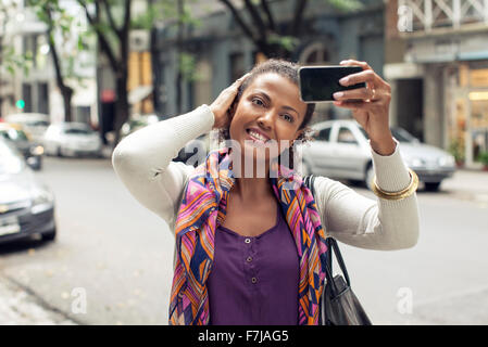 Femme de prendre la rue sur selfies Banque D'Images