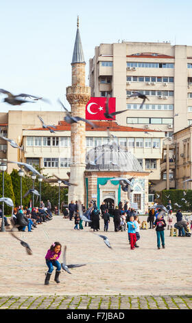 Izmir, Turquie - 5 Février 2015 : les enfants jouent avec des colombes sur Konak Square en face de l'ancienne mosquée Camii Banque D'Images