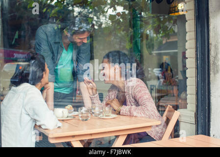 Parlez aux clients de serveur dans un café Banque D'Images