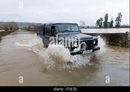 Welshpool, Powys, Pays de Galles, Royaume-Uni. 1er décembre, 2015. Météo : Paul Wilson, chauffeur poids-lourd, conduit sa nouveau Land Rover Defender dans les eaux d'inondation près de l'aéroport de Melbourne. La rivière Severn éclate c'est banques à Welshpool et provoque une inondation. Credit : Graham M. Lawrence/Alamy Live News. Banque D'Images
