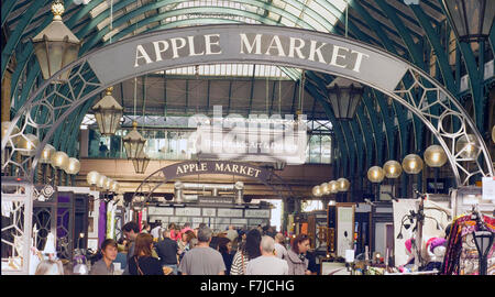 Avis des consommateurs et des étals de marché chez Apple , situé à l'intérieur de marché couvert de Covent Garden, London UK. Banque D'Images