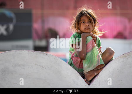 Pauvre fille assis sur un mur, portrait, Pushkar, Rajasthan, India Banque D'Images