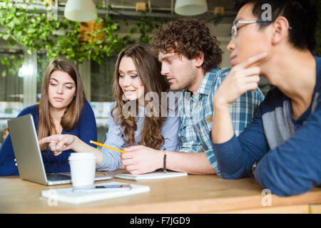 Groupe de partenaires d'affaires discuter nouveau projet et à l'aide d'ordinateur portable dans le bureau Banque D'Images