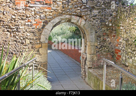 Une très ancienne silex et brique travail avec un chemin pavé d'Archway passant par le centre de l'arche et un passage de l'autre côté Banque D'Images