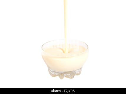 Verser le lait condensé avec le sucre dans un bol en verre isolated on white Banque D'Images