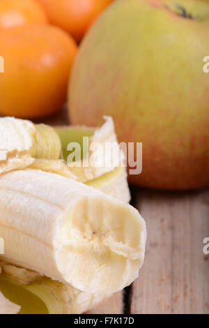 Mandarin les pommes et les bananes sur plaque de bois Banque D'Images