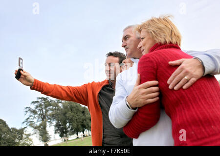 Famille prenant leur propre photo avec un téléphone Banque D'Images