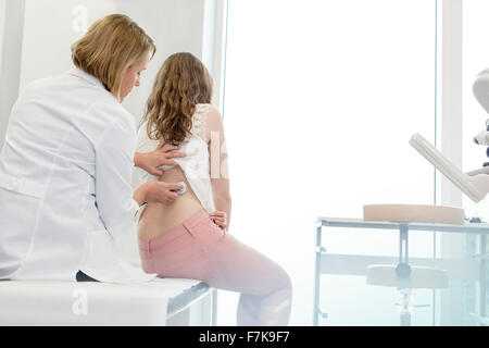 Médecin à l'aide en matière de stéthoscope dos du patient en salle d'examen Banque D'Images