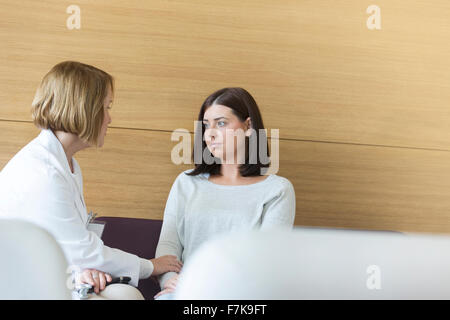 Médecin sérieux consolant patient dans un centre hall Banque D'Images