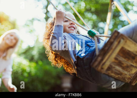 Carefree girl swinging in park Banque D'Images