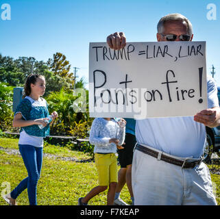 Holding signs manifestants dénonçant l'atout de Donald lors d'un rassemblement politique pour Trump à Sarasota, FL Banque D'Images