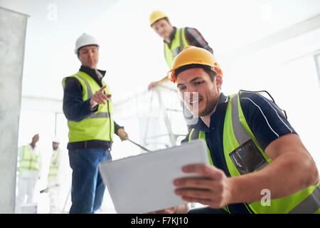 Les travailleurs de la construction with digital tablet at construction site Banque D'Images