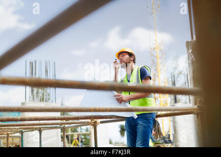 Avec l'aide de plans d'ingénieur walkie-talkie at construction site Banque D'Images