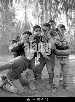 Les jeunes garçons tunisien une grève posent à la palmeraie de Tozeur.Tozeur, Tunisie. L'Afrique du Nord. Banque D'Images