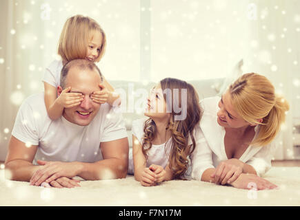 Smiling parents et deux petites filles à la maison Banque D'Images