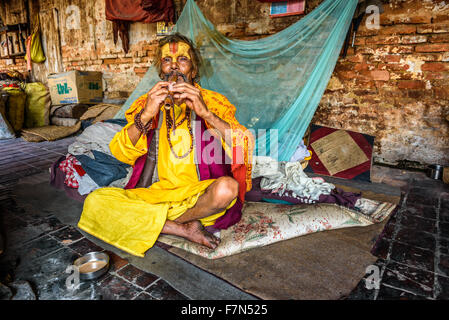 Sadhu baba (saint homme) vivant à Pashupatinath Temple joue un tuyau Banque D'Images